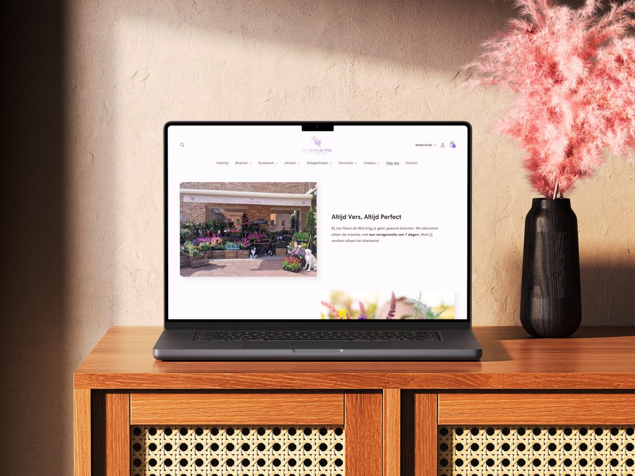 Laptop toont bloemenwinkel website op houten meubel.