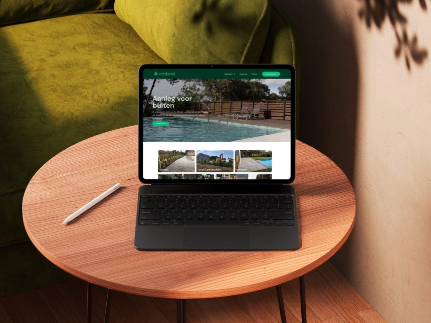 Laptop op houten tafel met website en pen.